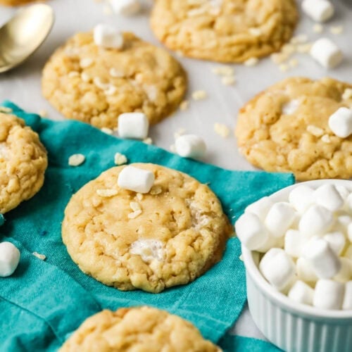 Rice krispie cookies surrounded by mini marshmallows and cereal pieces.