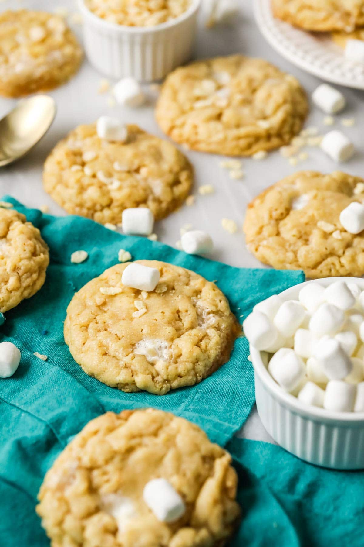 Rice krispie cookies surrounded by mini marshmallows and cereal pieces.