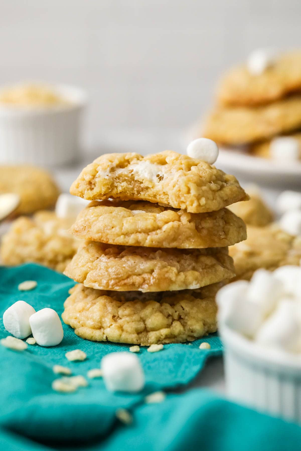 Stack of four rice krispie cookies with the top cookie missing a bite.