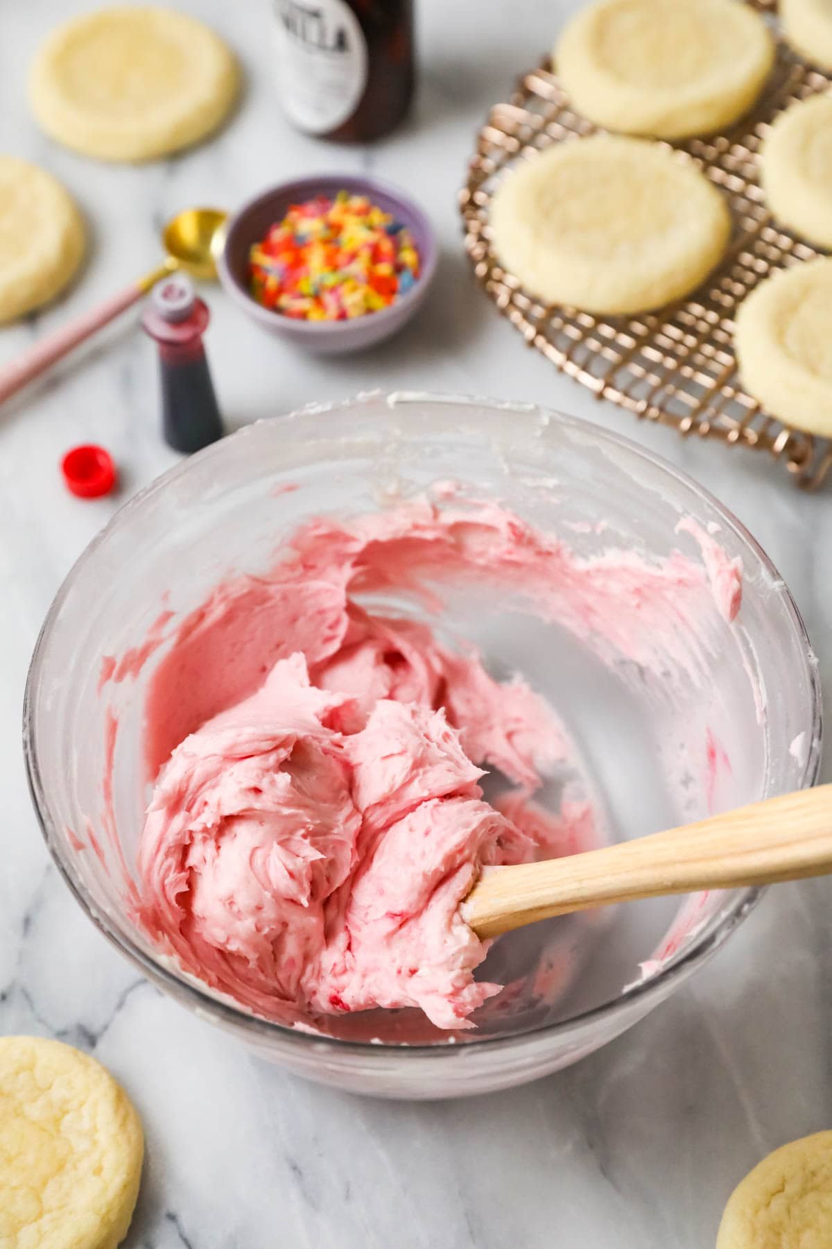 Bowl of pink frosting to be spread on soft sugar cookies.