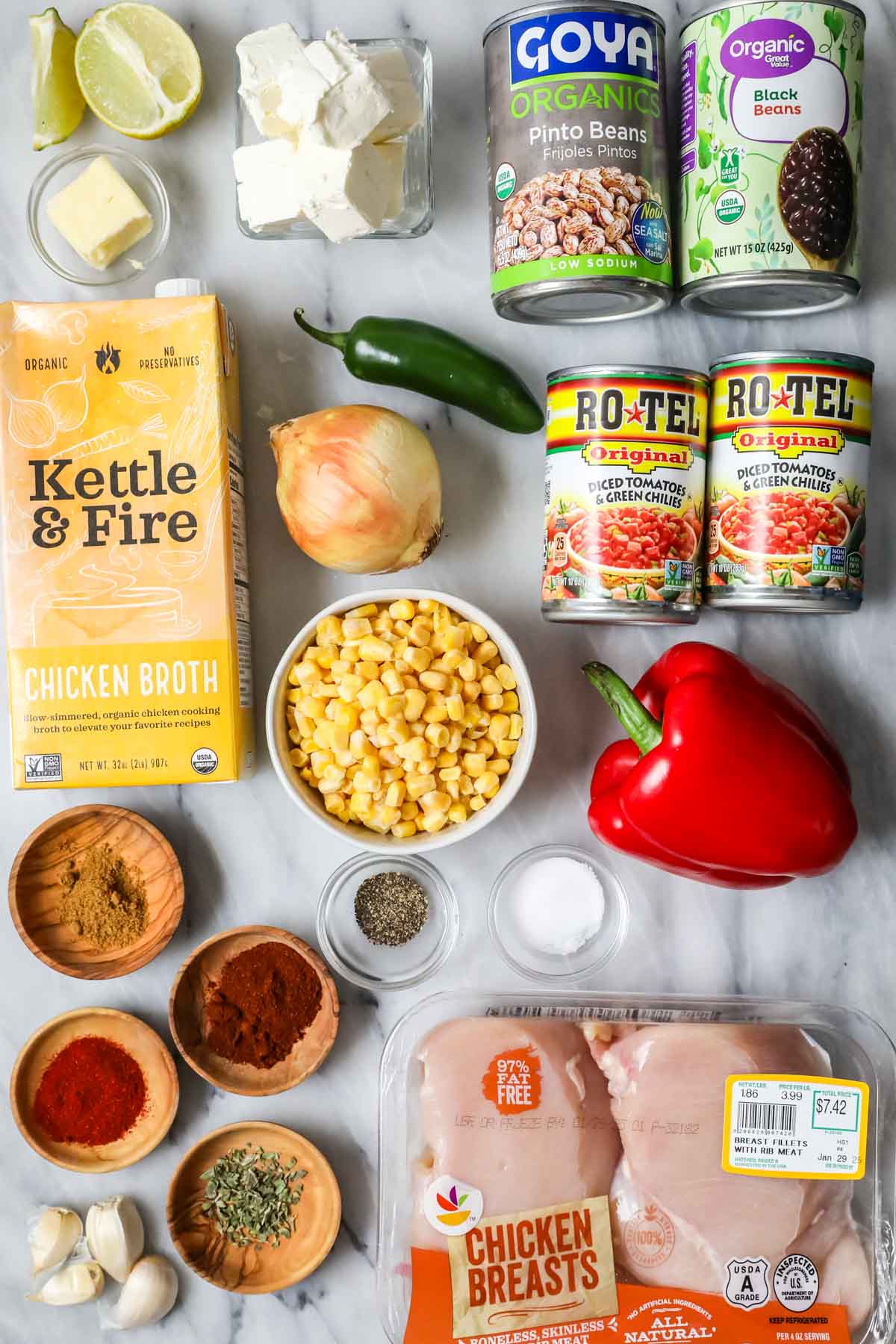 Overhead view of ingredients including rotel, chicken, broth, beans, and more.