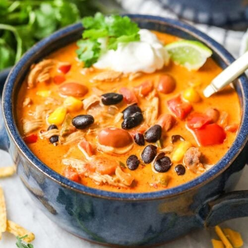 Bowl of creamy southwest chicken soup made with beans, chicken, peppers, and more.