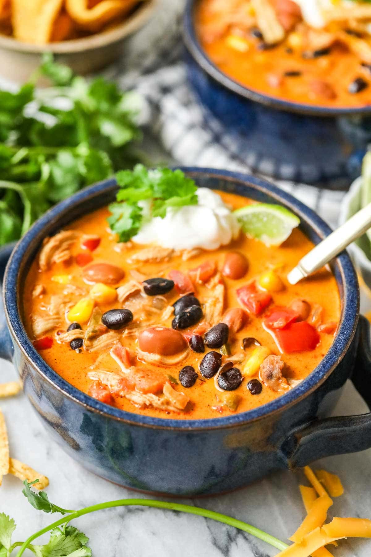 Bowl of creamy southwest chicken soup made with beans, chicken, peppers, and more.