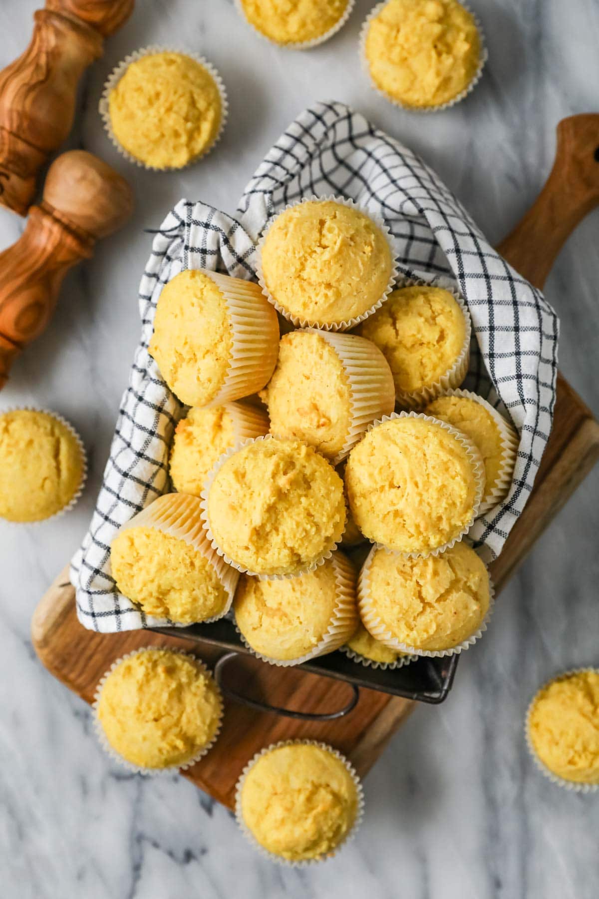 Overhead view of cornbread muffins in a towel lined dish.