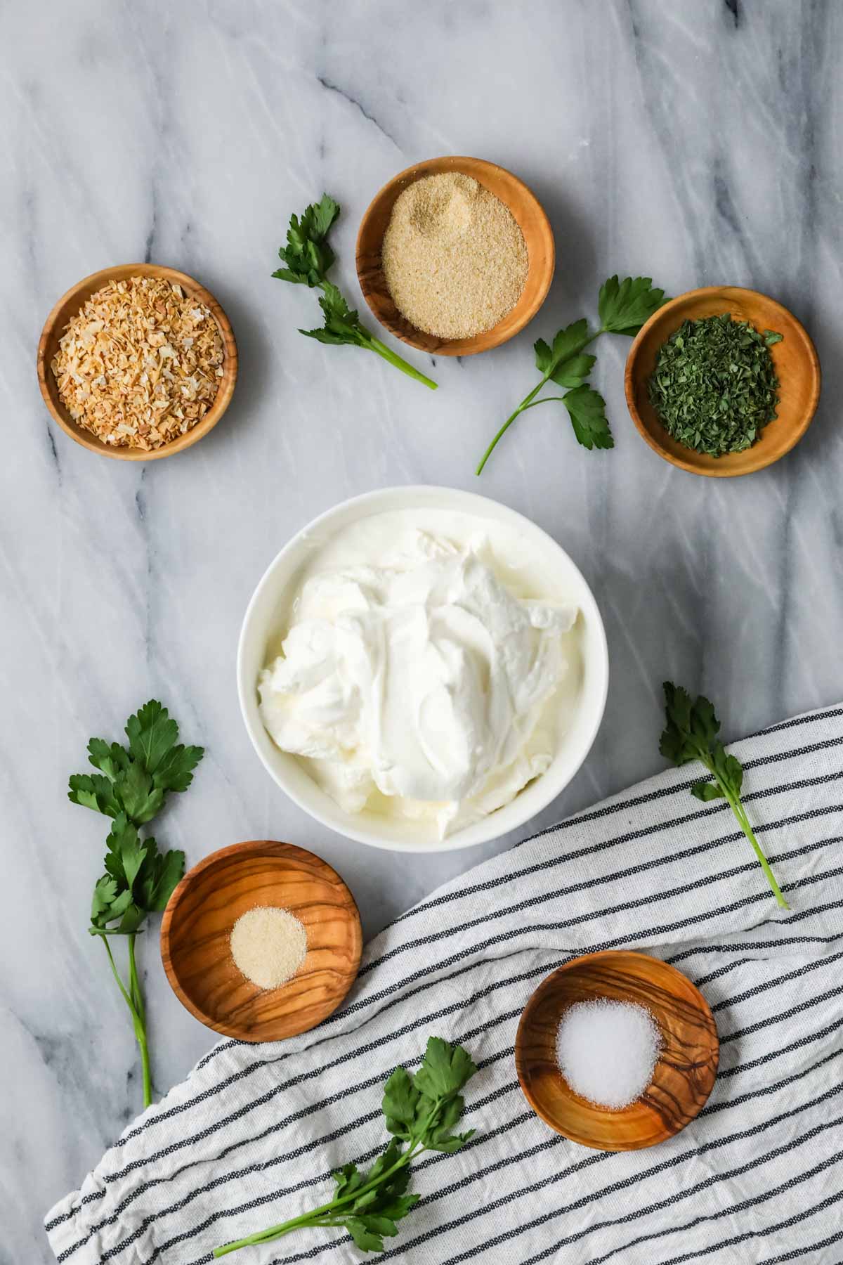 Overhead view of ingredients including sour cream, spices, and fresh chives.