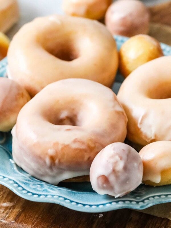 Plate of sourdough donuts and donut holes that have been dipped in a vanilla glaze.