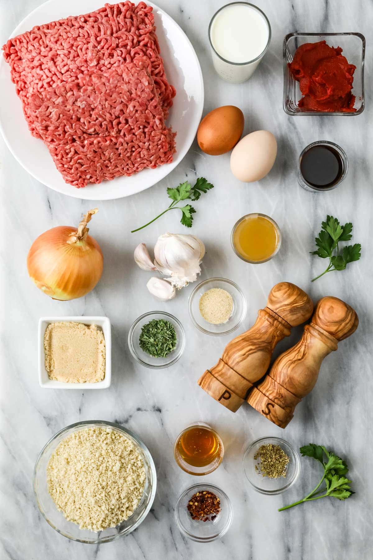 Overhead view of ingredients including ground beef, tomato paste, Worcestershire sauce, and more.