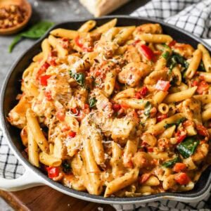 Skillet of tuscan chicken pasta made with spinach and sun dried tomatoes.