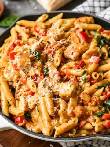 Skillet of tuscan chicken pasta made with spinach and sun dried tomatoes.