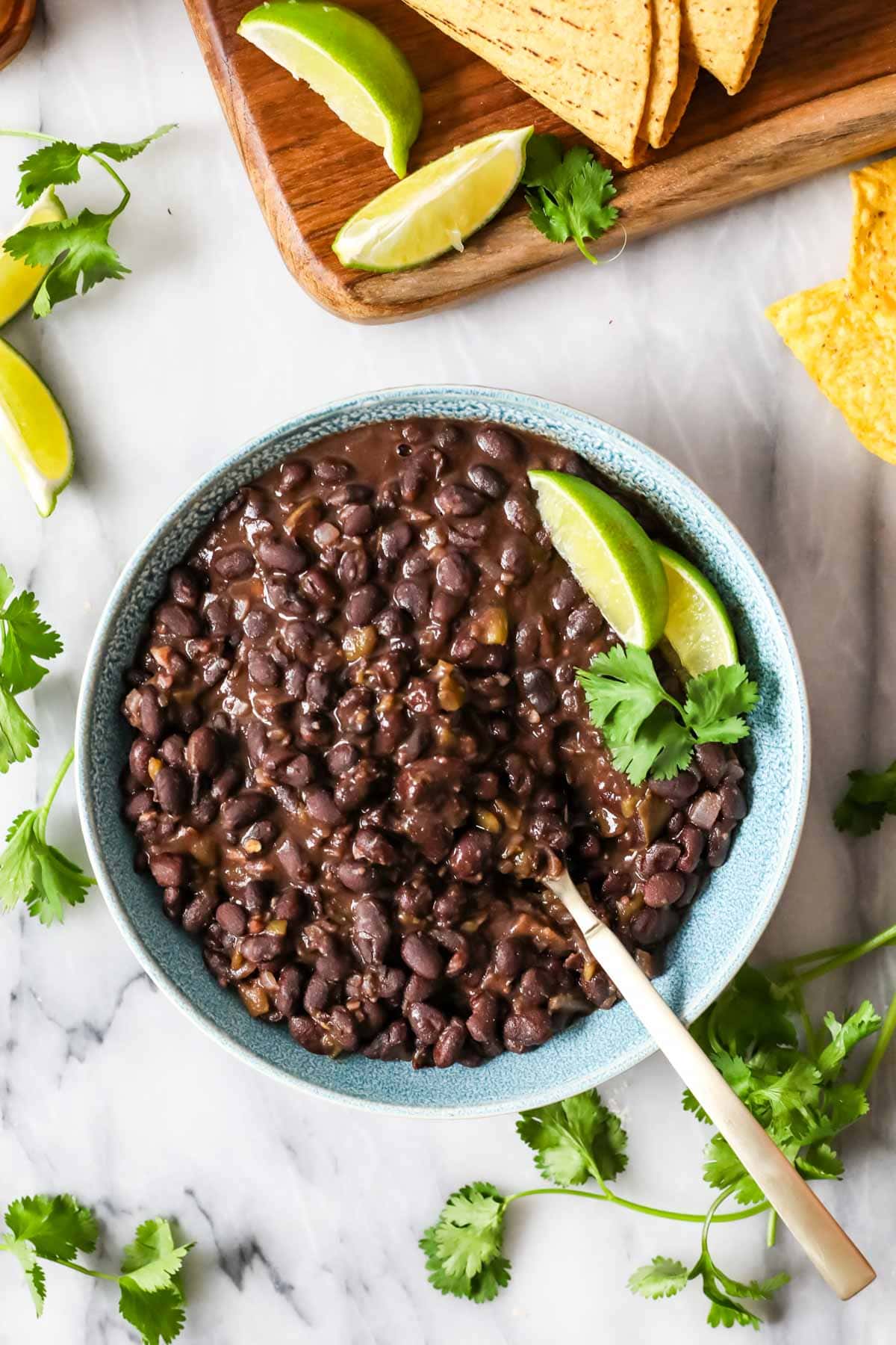 Overhead view of a bowl of cuban beans topped with lime and cilantro.