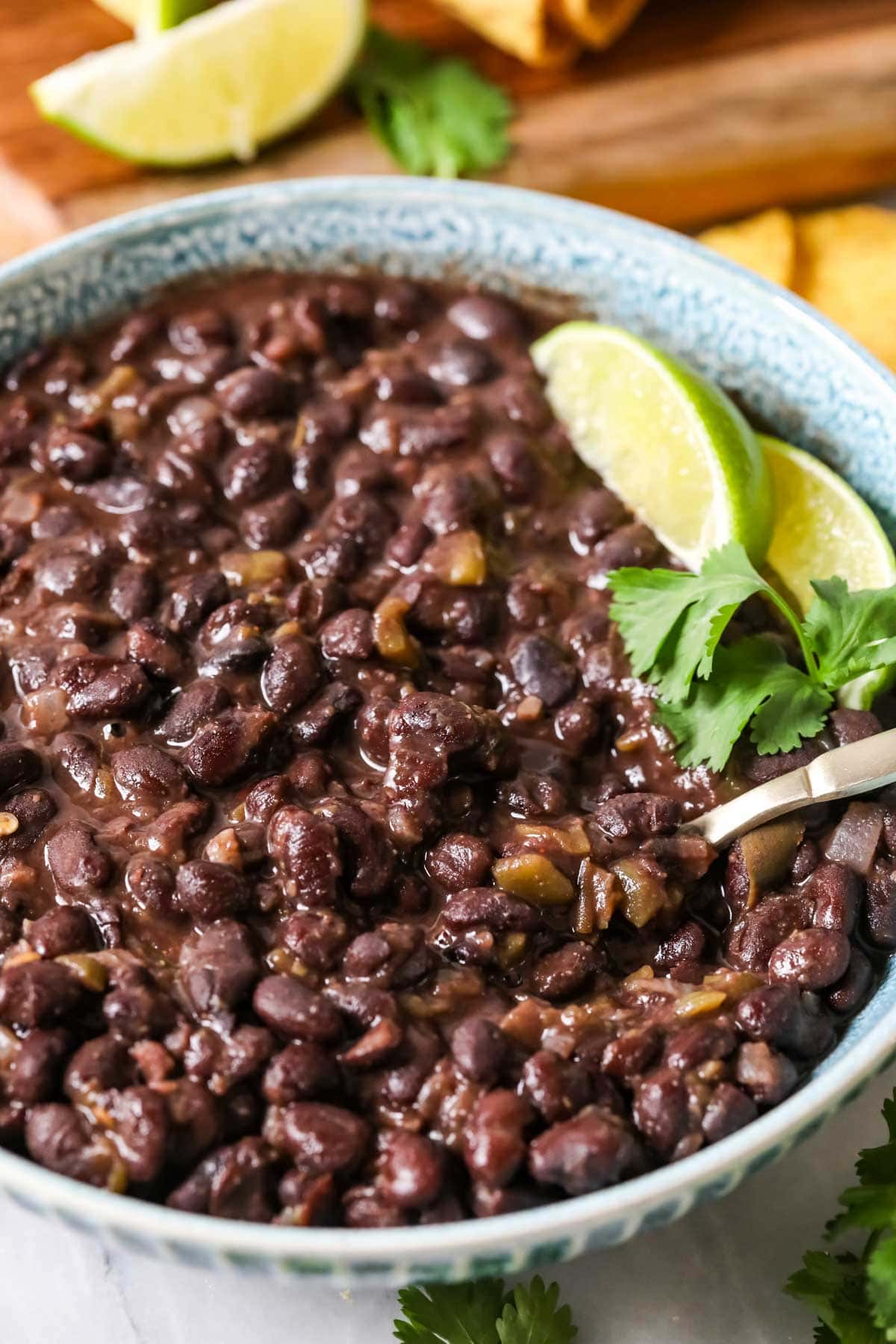 Bowl of cuban-style black beans topped with lime and cilantro.