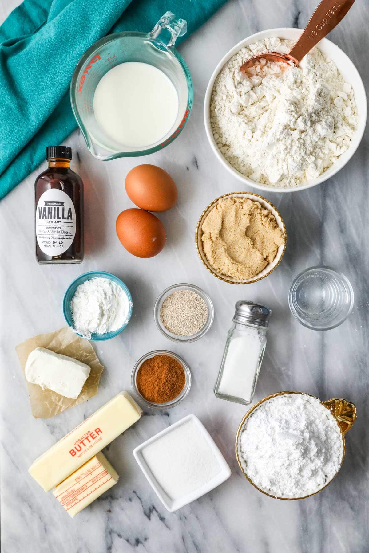 Overhead view of ingredients including yeast, brown sugar, cinnamon, butter, and more.