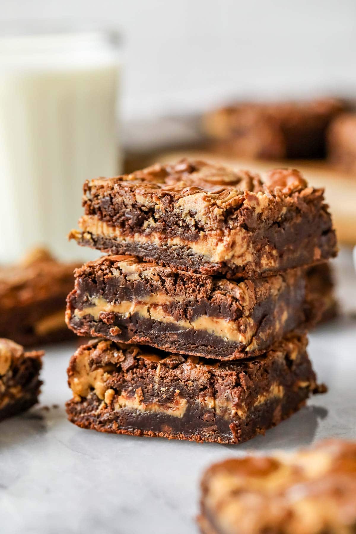 Stack of three peanut butter brownies with a distinct peanut butter layer inside and swirled tops.