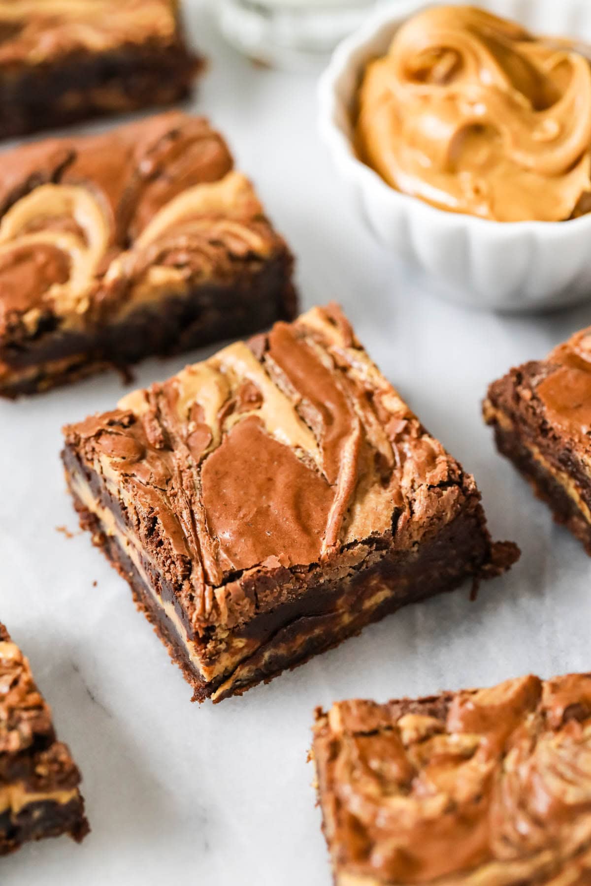 Overhead view of peanut butter brownies beside a bowl of peanut butter.