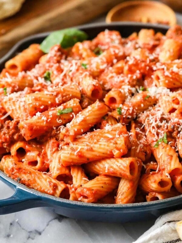 Skillet of homemade rigatoni topped with freshly grated parmesan cheese.