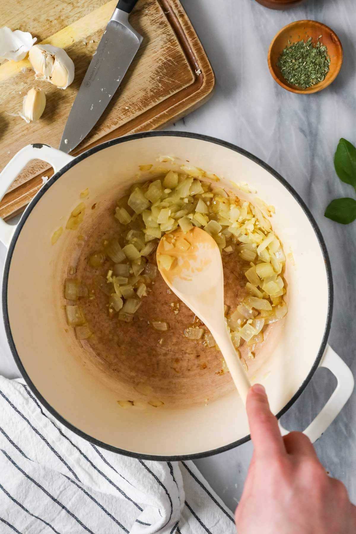 Overhead view of onions sauteing in a pot.
