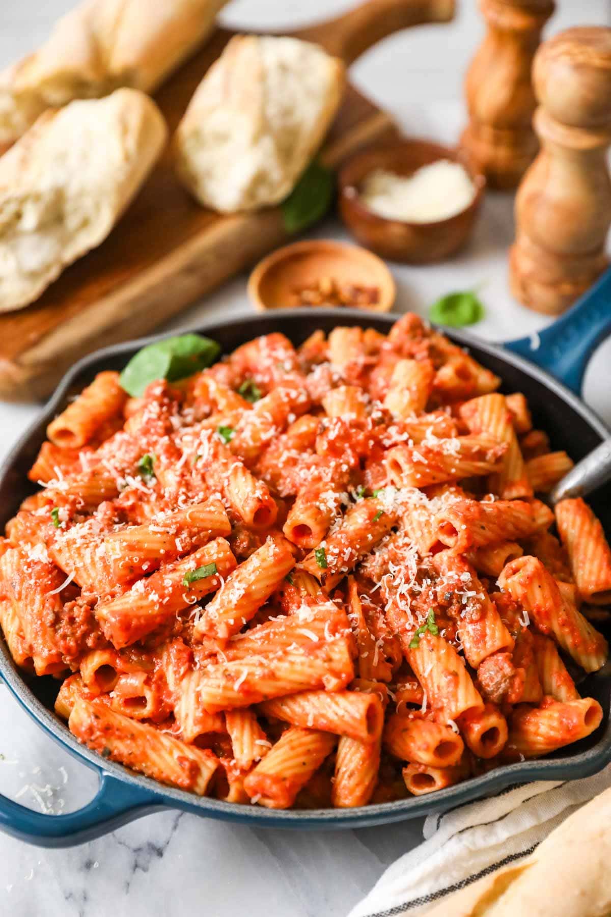 Skillet of homemade rigatoni topped with freshly grated parmesan cheese.