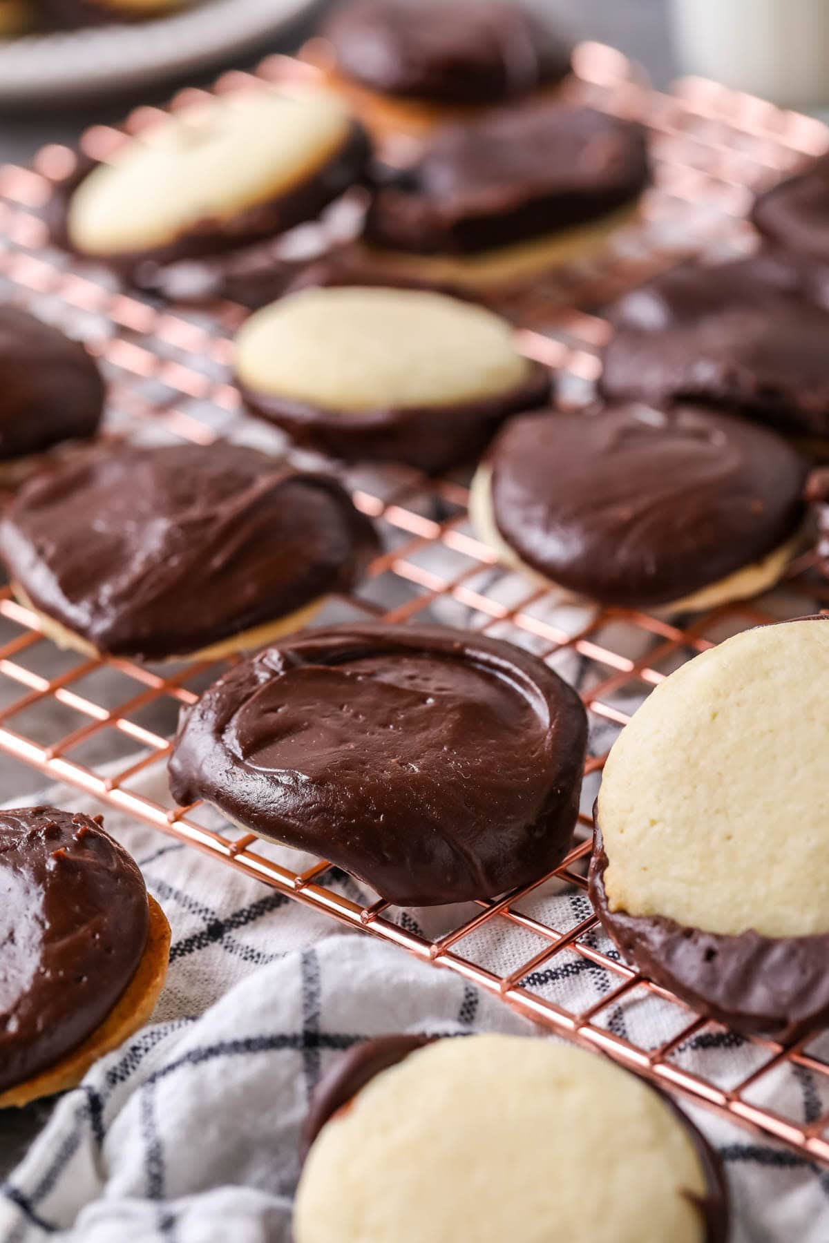 Cookies on a cooling rack with a very thick chocolate frosting on top.