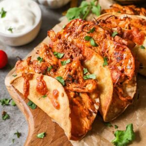 Crispy chicken tacos on wooden cutting board.