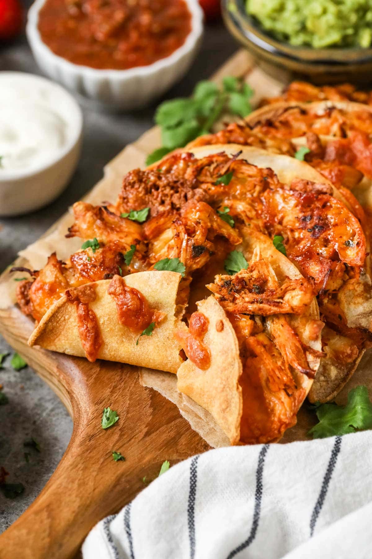 Crispy chicken tacos on wooden cutting board.