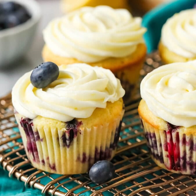 Lemon blueberry cupcakes on a cooling rack.