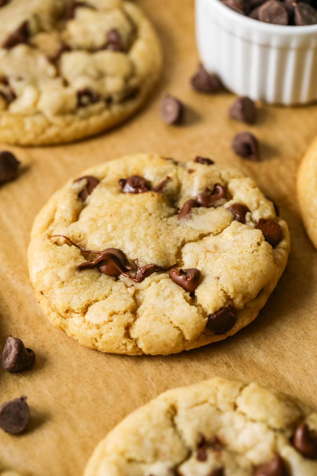 Close-up view of a soft and chewy chocolate chip cookie on a cookie sheet.