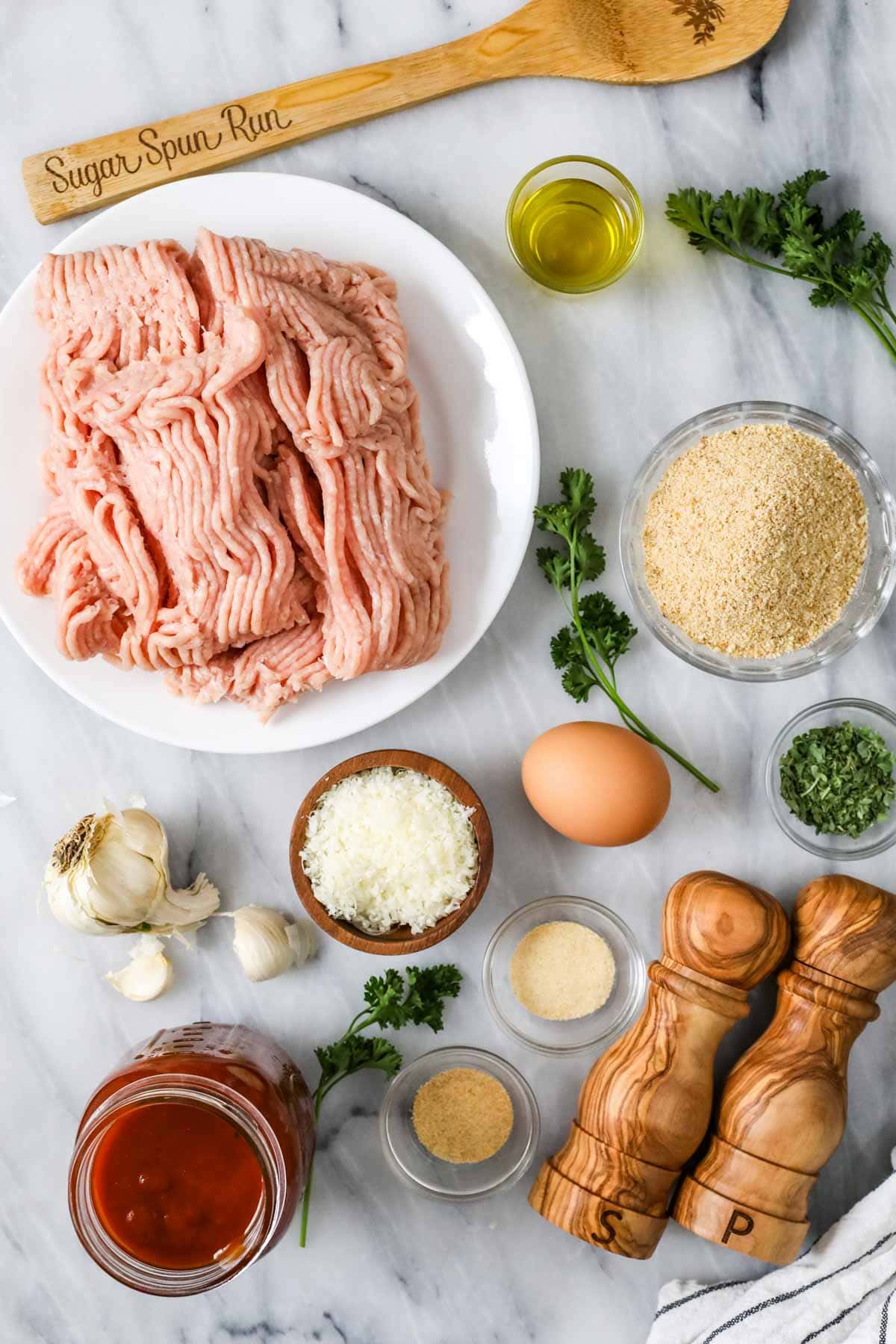 Overhead view of ingredients including ground chicken, BBQ sauce, breadcrumbs, and more.