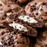 Arrangement of black bottom cookies with the center cookie broken in half showing a cream cheese center.