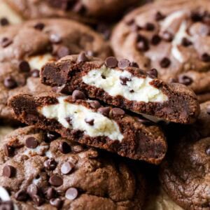 Arrangement of black bottom cookies with the center cookie broken in half showing a cream cheese center.