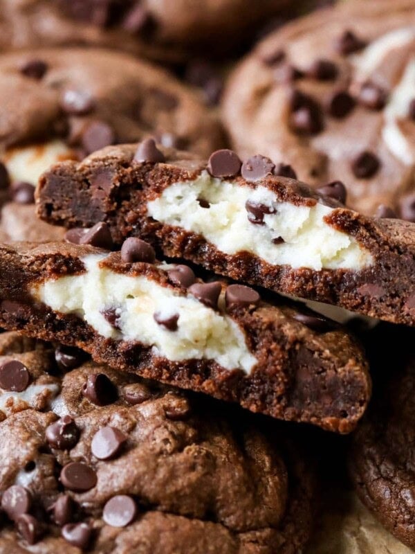 Arrangement of black bottom cookies with the center cookie broken in half showing a cream cheese center.