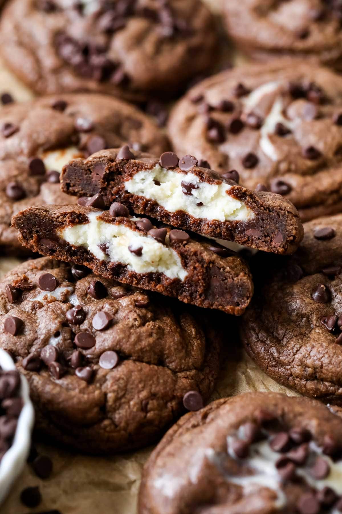 Arrangement of black bottom cookies with the center cookie broken in half showing a cream cheese center.