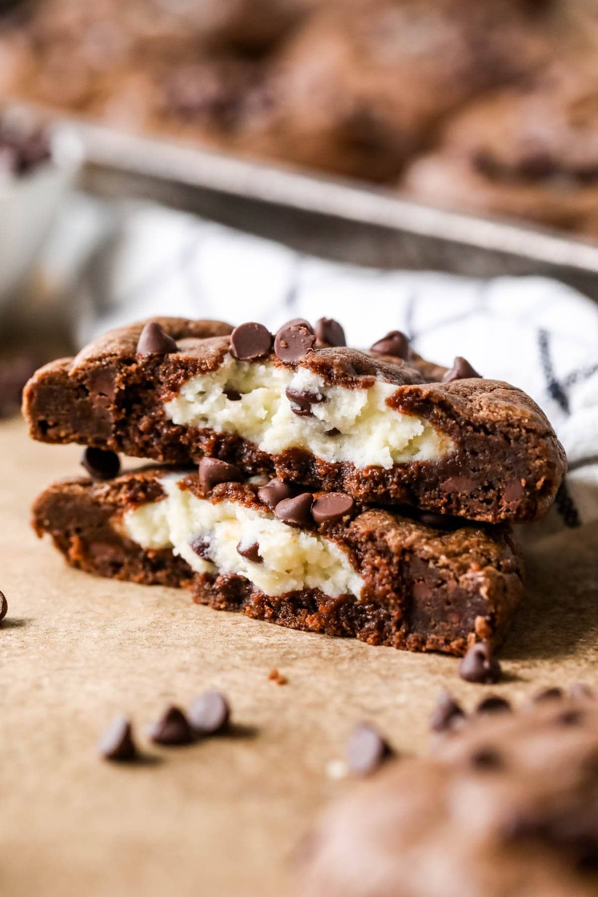 Two halves of a black bottom cookie stacked showing a cream cheese center.
