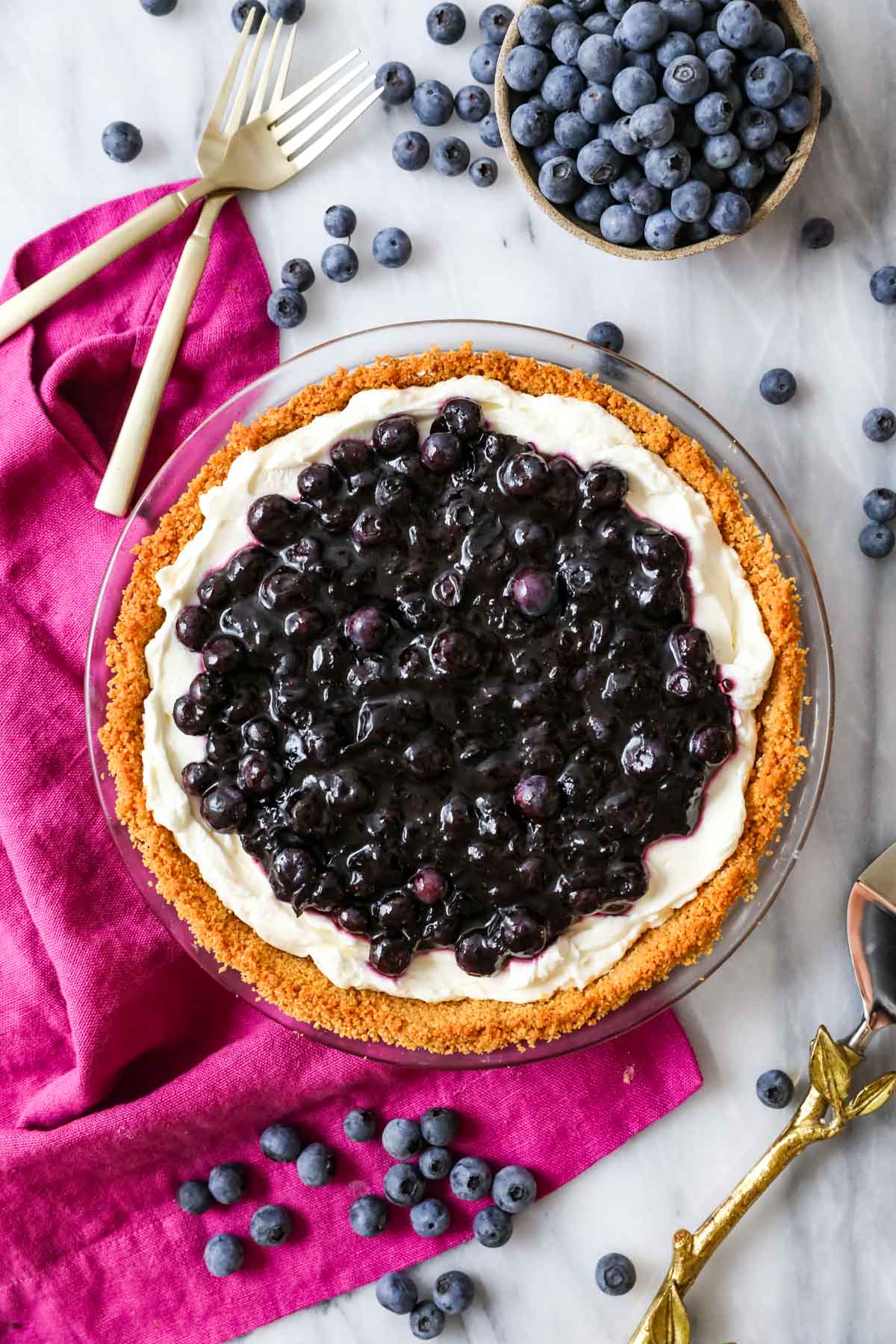Overhead view of a blueberry cream cheese pie in a graham cracker crust.