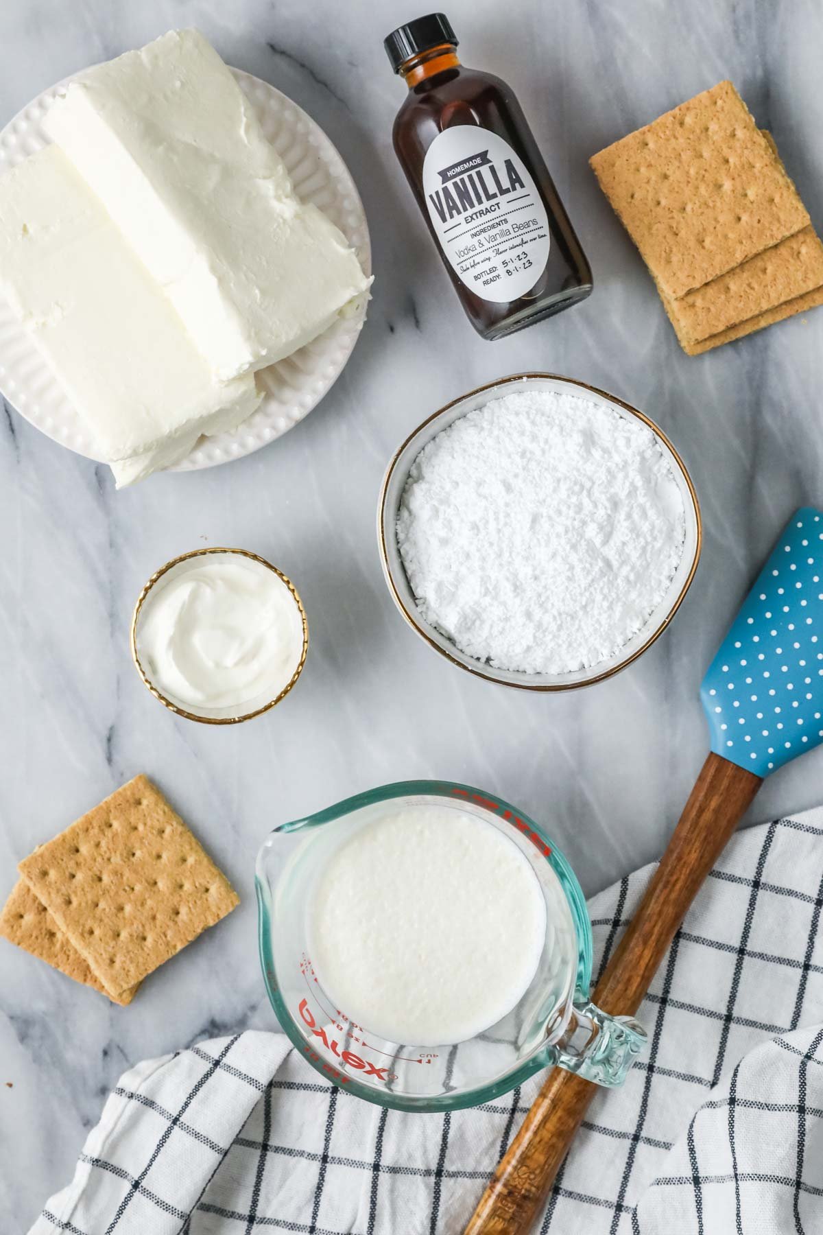 Overhead view of ingredients including cream cheese, whipped cream, graham crackers, and more.