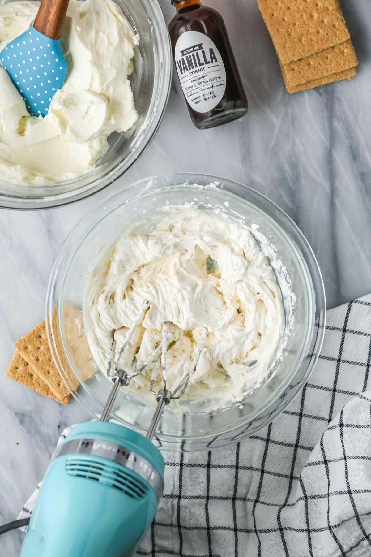 Overhead view of cream being whipped with an electric mixer.