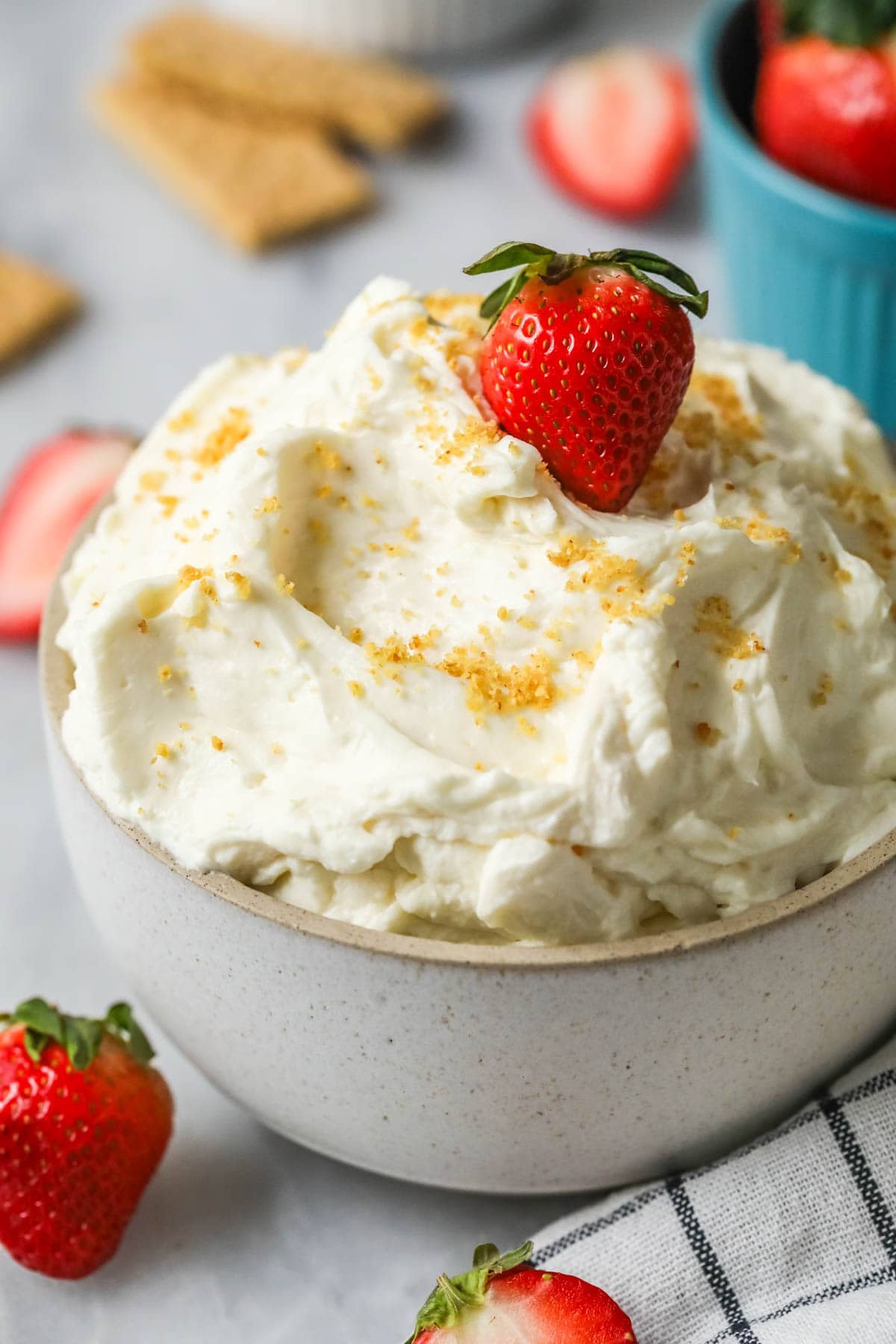 Cheesecake dip topped with graham cracker crumbs and a strawberry.
