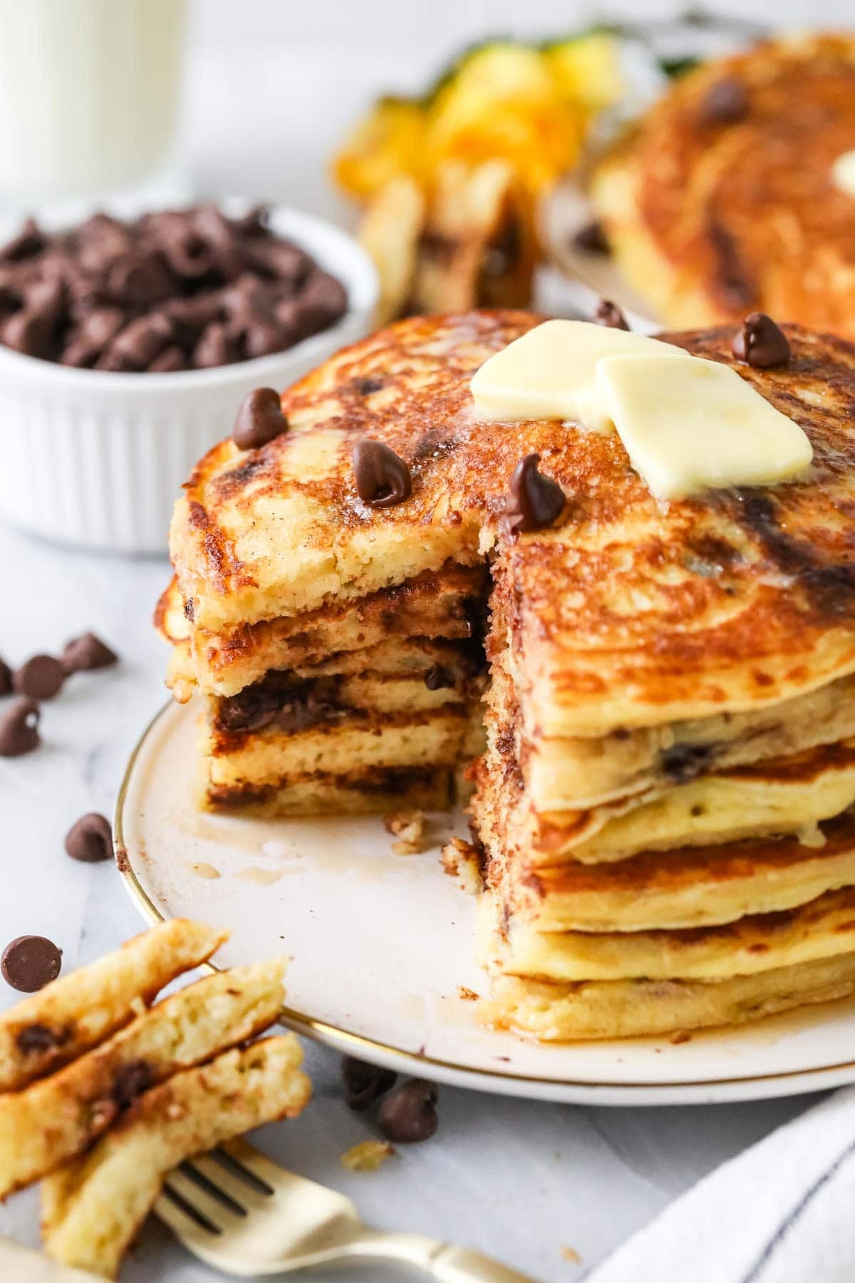 Forkful missing from a stack of pancakes made with chocolate chips.