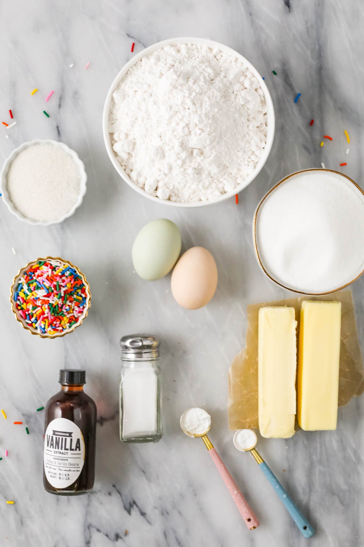 Overhead view of ingredients including butter, cake flour, sprinkles, and more.