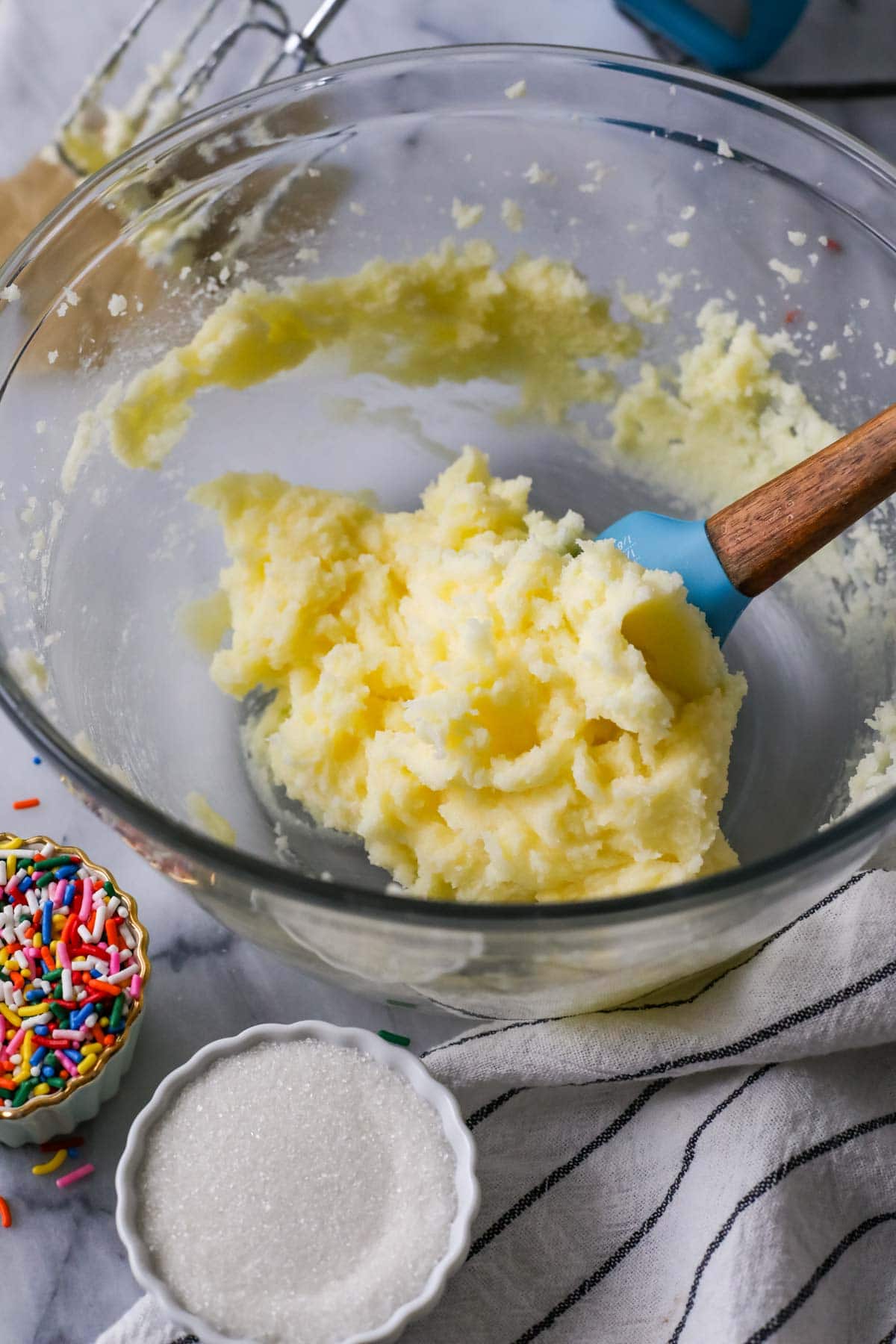 Spatula showing creamed butter and sugar in a bowl.