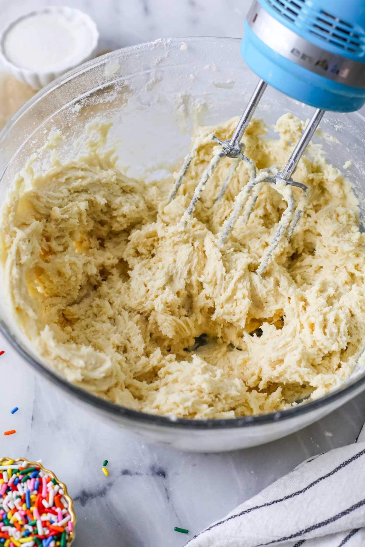 Beaters mixing a cookie dough together in a bowl.