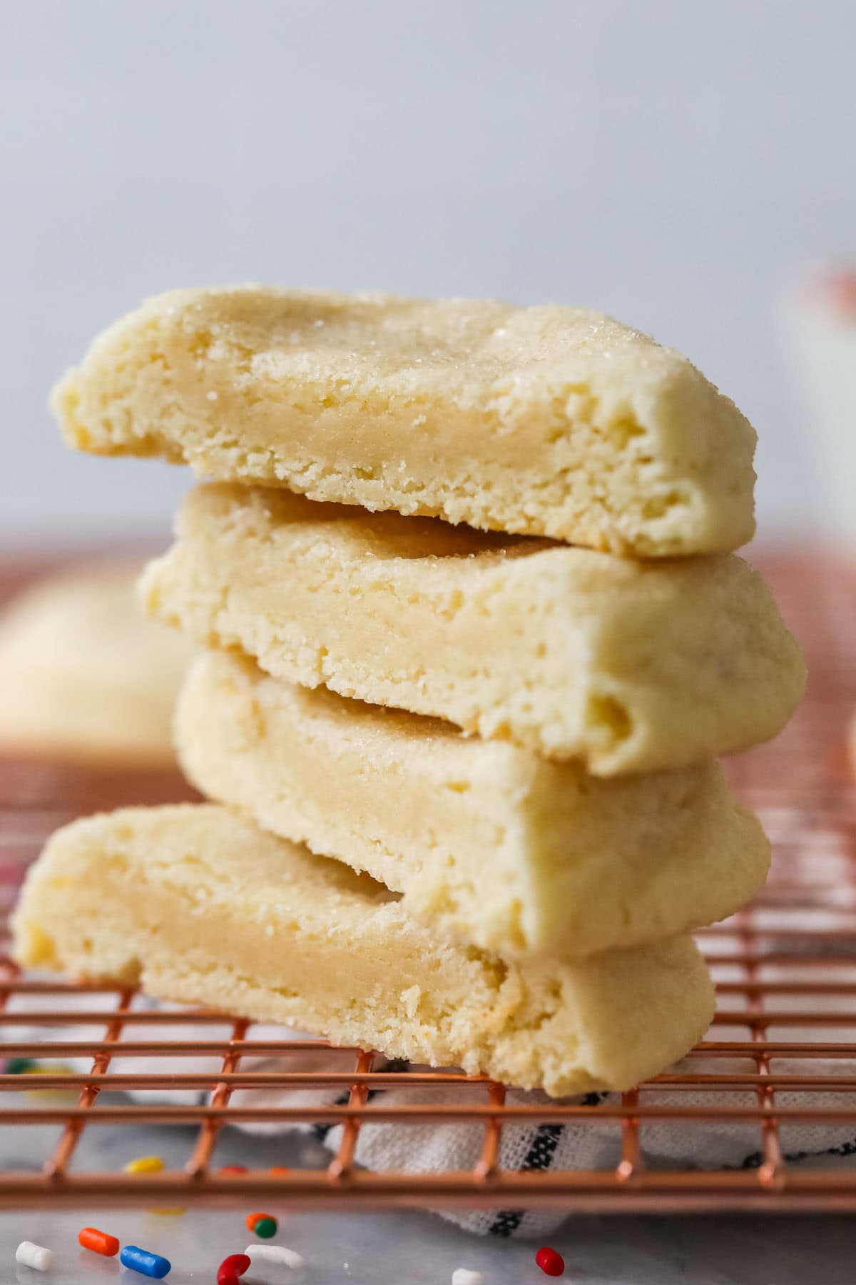 Stack of four halves of thick and buttery gourmet sugar cookies.