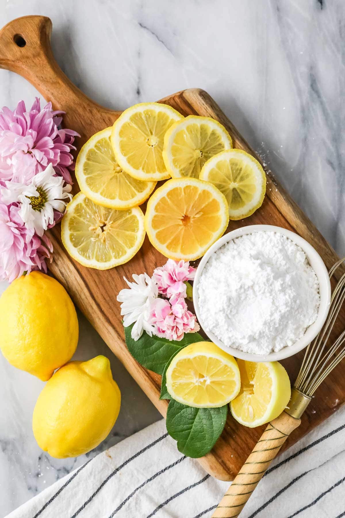 Overhead view of ingredients including lemons and powdered sugar.
