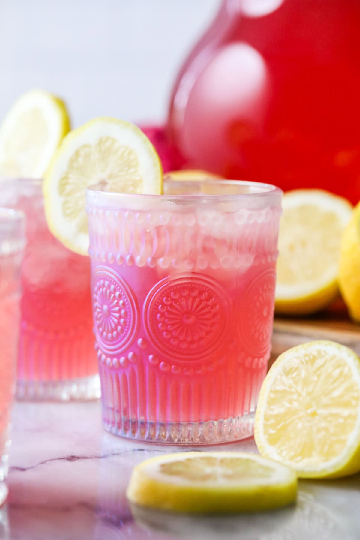 A glass of lemonade, a natural pink made with cranberry juice.