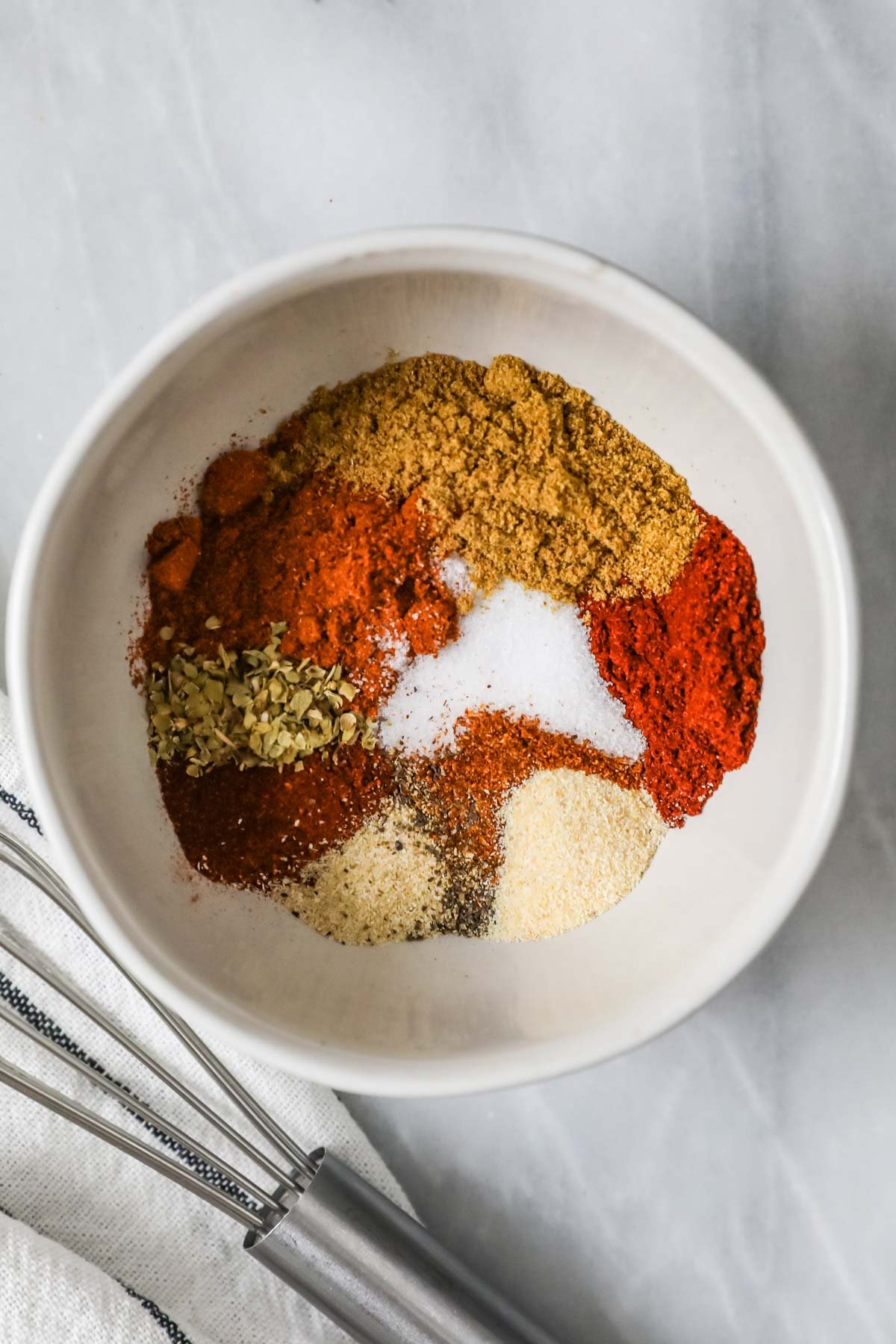 Elevated view of a bowl of spices including cumin, garlic powder, chili powder, etc.