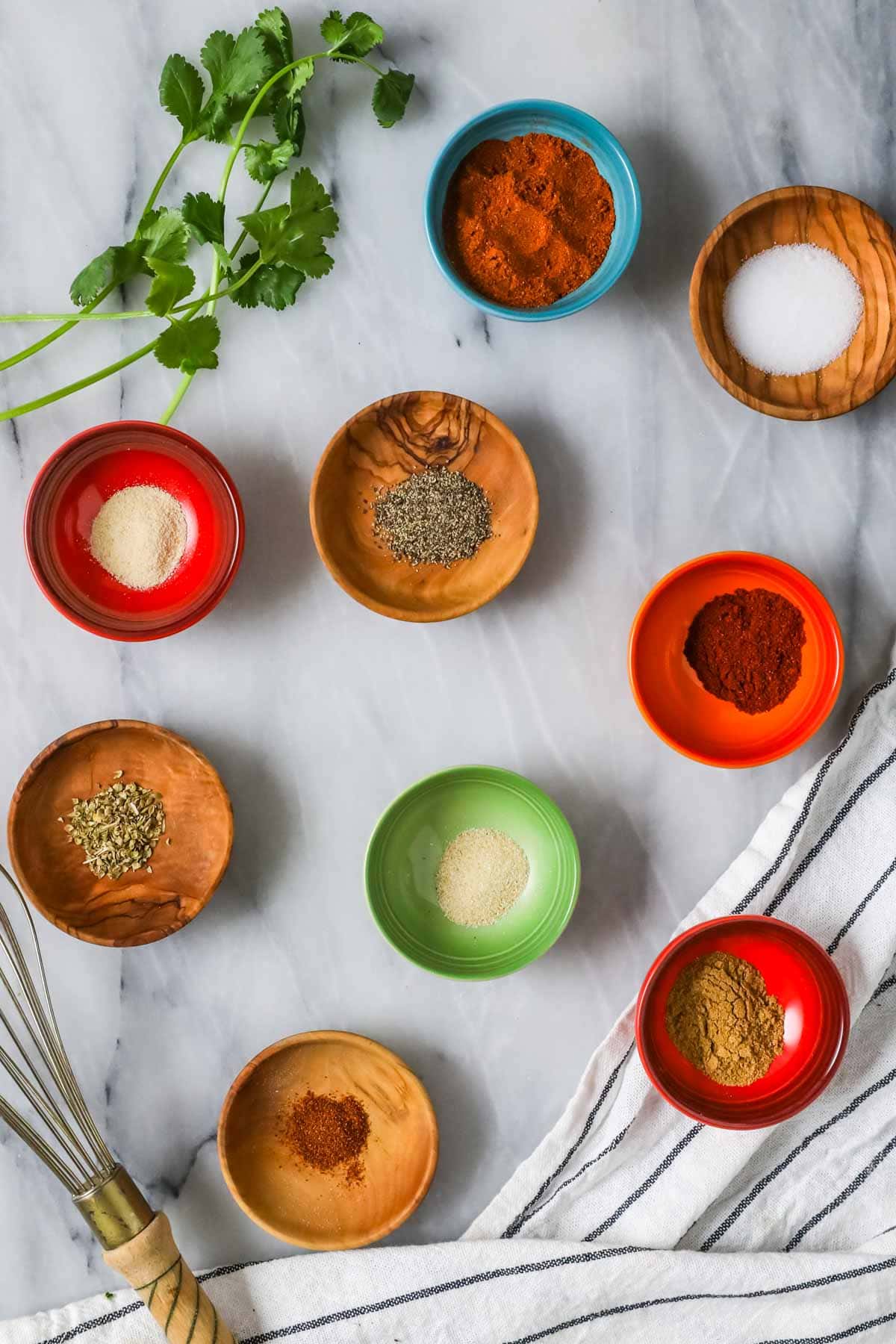 Elevated landscape of nine colorful spice dishes.