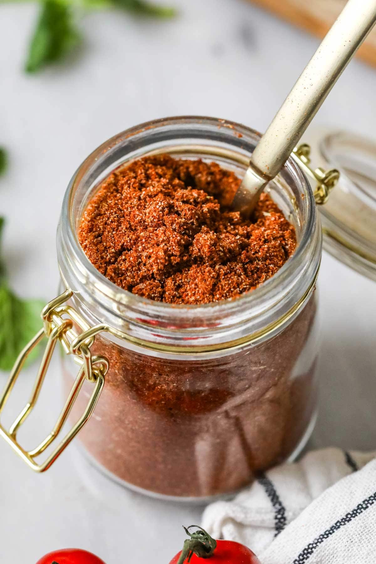 A can of homemade taco seasoning with a tablespoon in it.