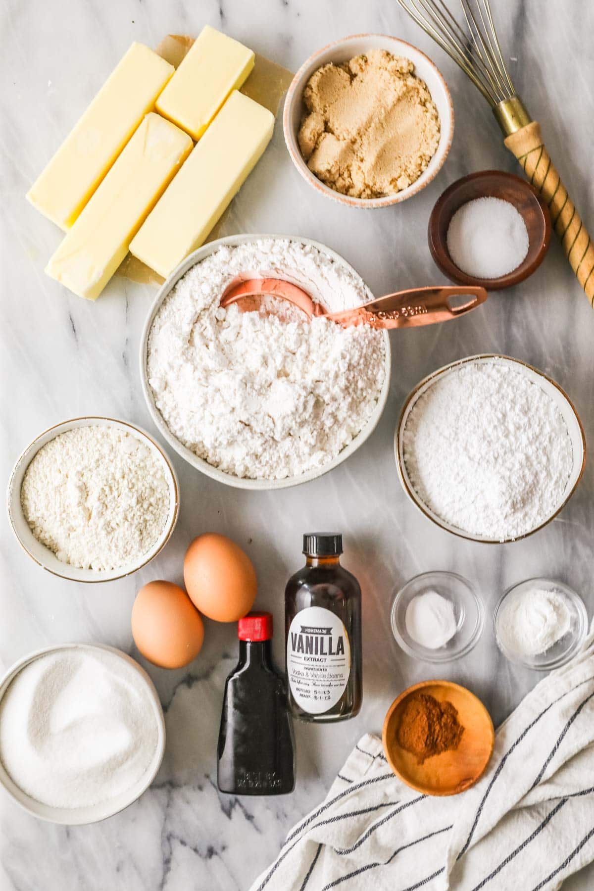 Overhead view of ingredients including butter, maple extract, cinnamon, cake flour, and more.