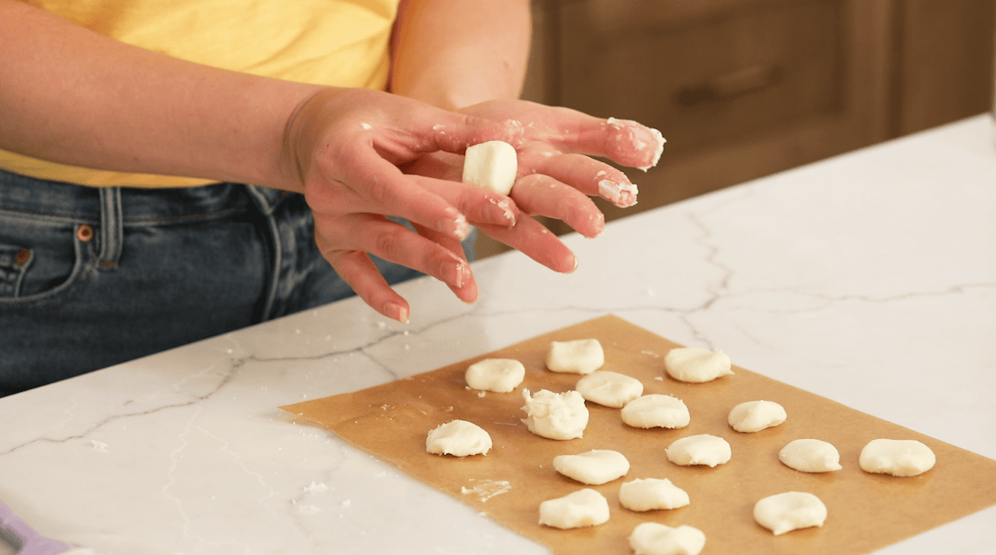 Hands forming buttercream into the shape of butter pats.