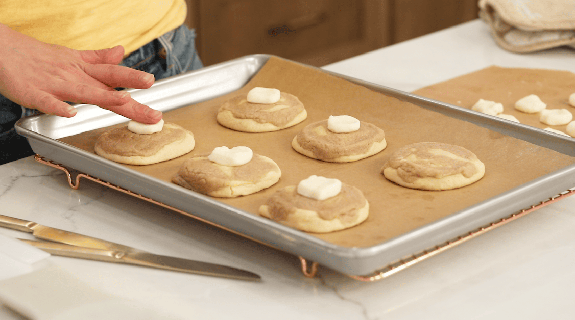 Adding butter pats to top of warm French toast cookies.
