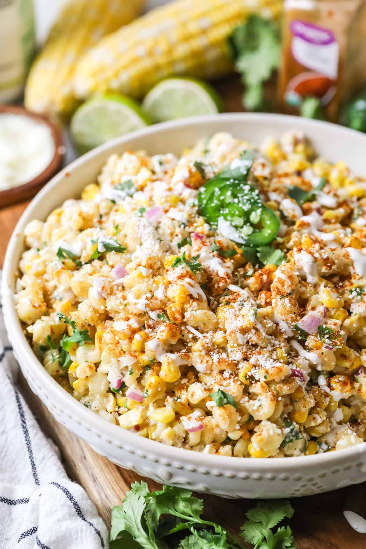 Bowl of Mexican street corn pasta salad topped with cilantro, jalapeno, cotija cheese, and chili powder.